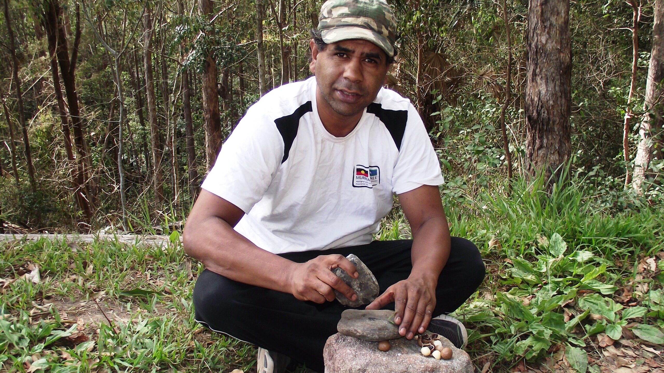 Lyndon Davis cracking macadamia nuts with an anvil stone 