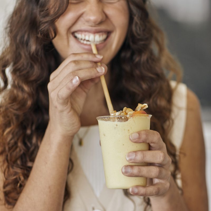 Summer-smoothie-with-macadamia-sprinkles-and-person-scaled